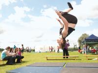 A young gymnast performs an aerial somersault