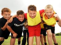 Four young boys huddle towards the camera