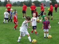 Young children participate in a game of football